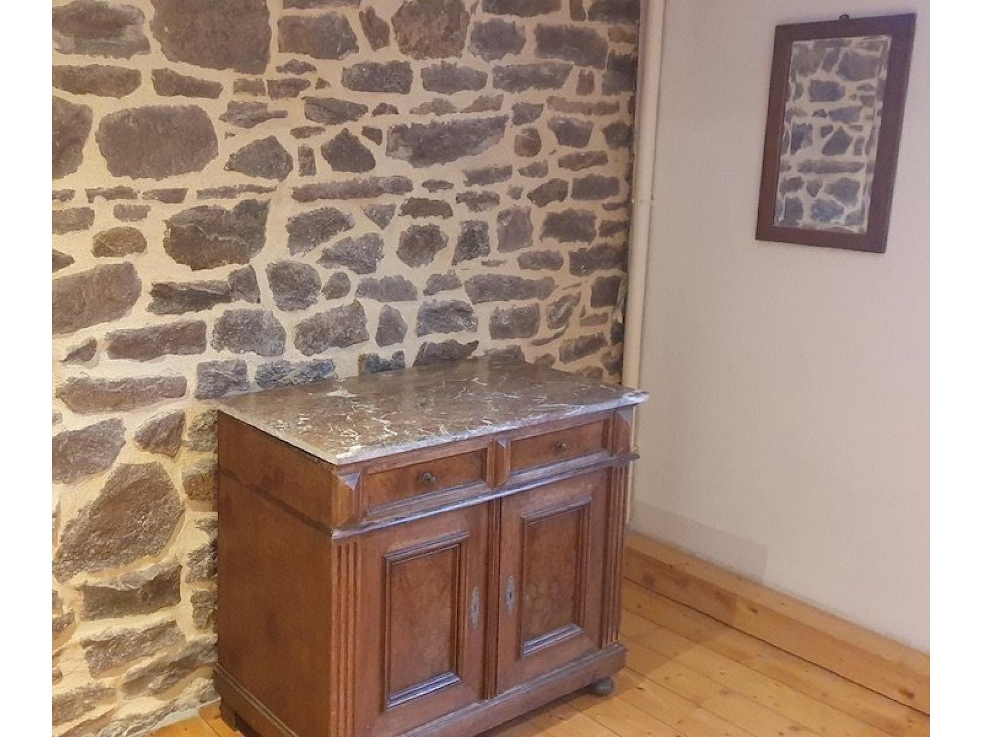 Kommode vor Steinmauer